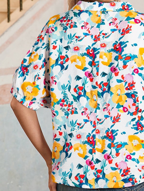 Person wearing a colorful floral shirt with a blurred background
