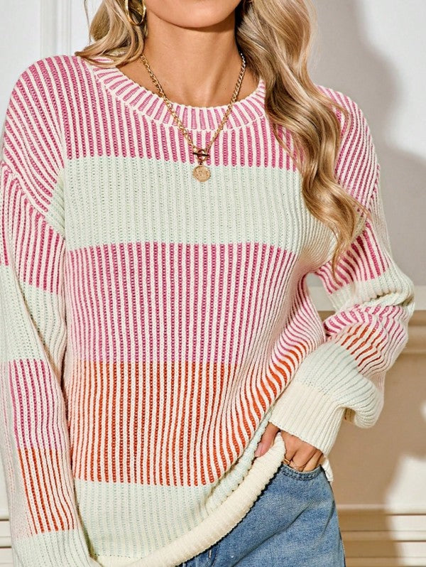 Person wearing a colorful striped sweater with a neutral background