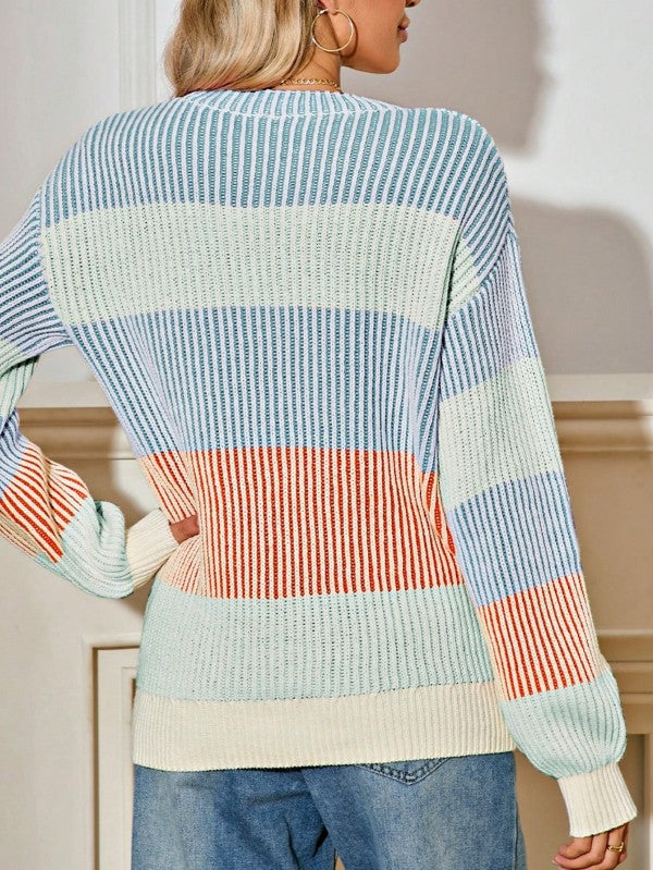 Person wearing a colorful striped sweater with a neutral background