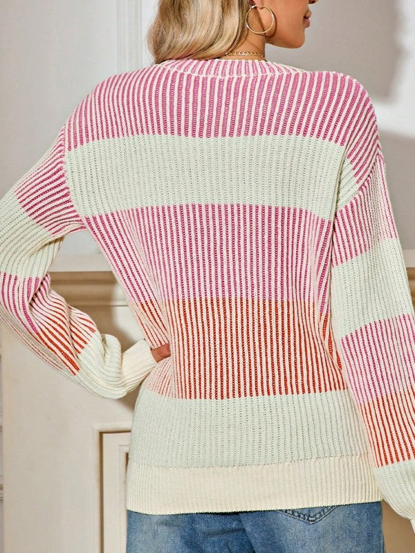 Person wearing a colorful striped sweater with a neutral background