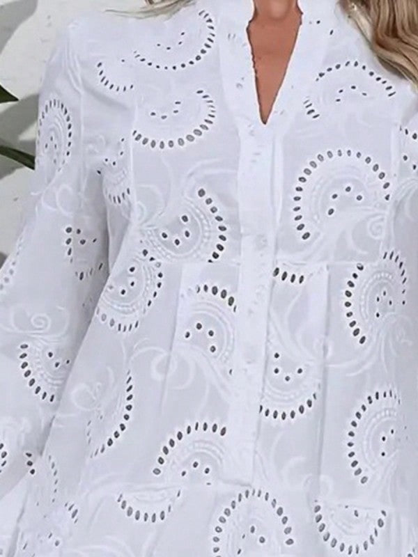 White embroidered dress with intricate patterns on a blurred background