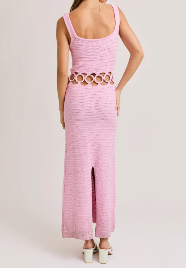 Pink crochet dress with cut-out design on a plain background