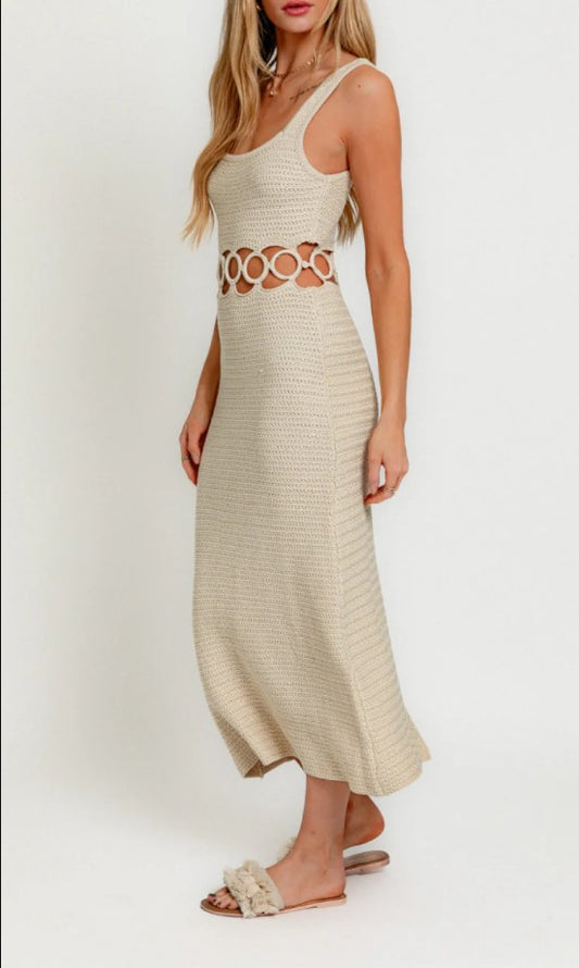 Woman wearing a beige dress with cut-out design on a white background