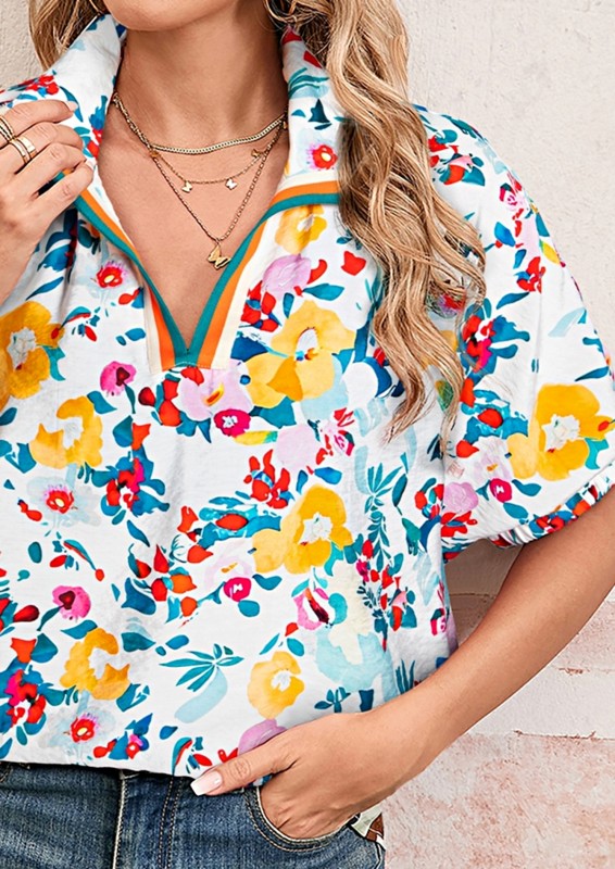 Woman wearing a colorful floral blouse with a neutral background