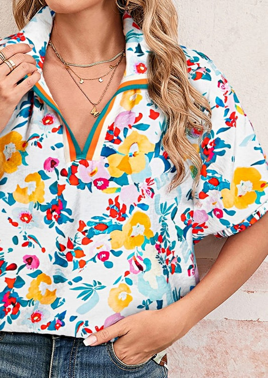 Woman wearing a colorful floral blouse with a neutral background