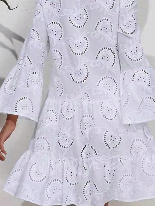 White dress with intricate cut-out pattern on a plain background