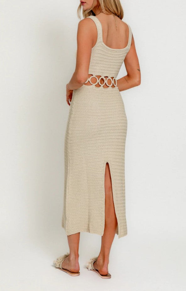 Woman wearing a beige knit dress with a belt on a white background