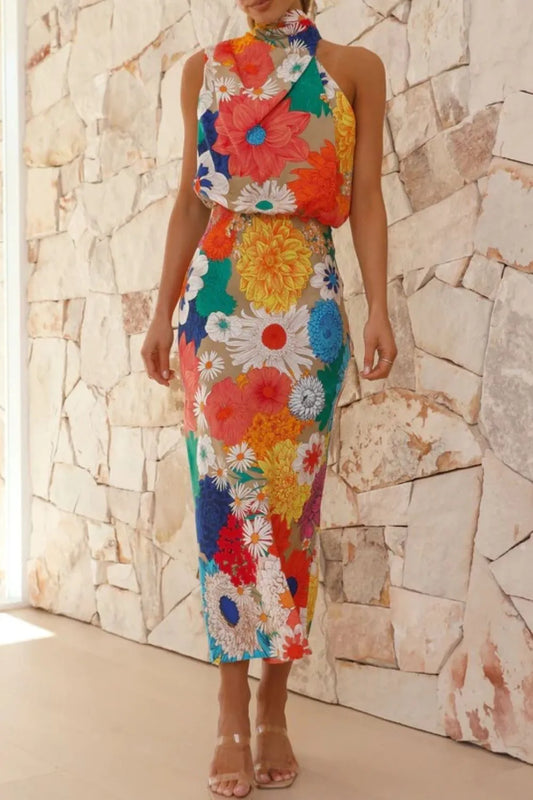 Woman wearing a colorful floral dress against a stone wall.