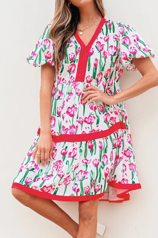 Woman wearing a floral dress with pink tulips on a white background