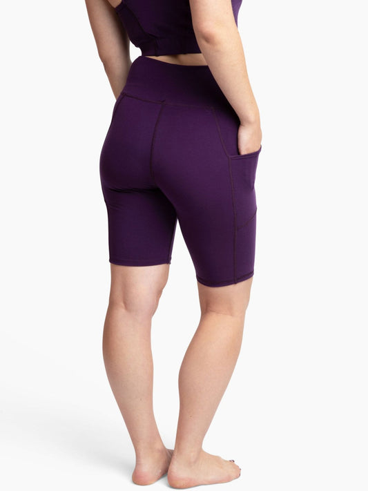 Person wearing purple athletic shorts on a white background